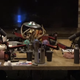 Joe Rogan in headset sits in front of a microphone sits across from Mark Zuckerberg with identical setup.